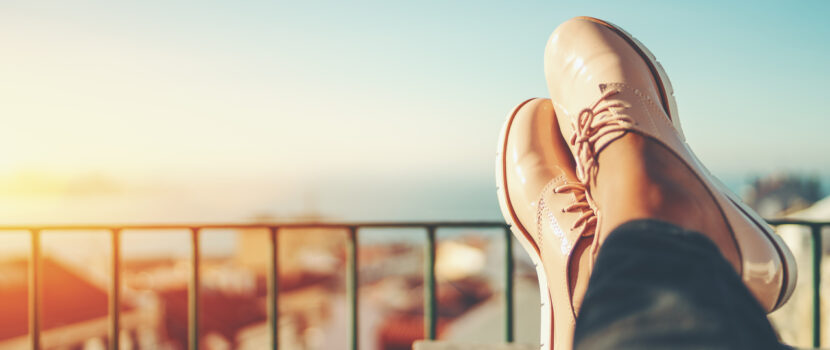 Close up of a woman sitting with their feet up on a balcony