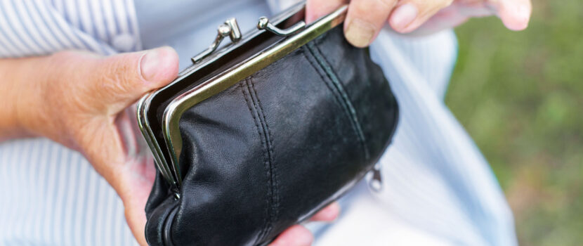 Hands of an elderly woman holding a purse