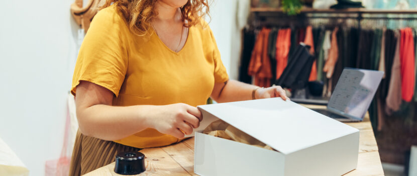 A woman packing an order in a clothing studio.