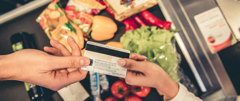 A customer handing over a bank card to pay for goods in a supermarket.