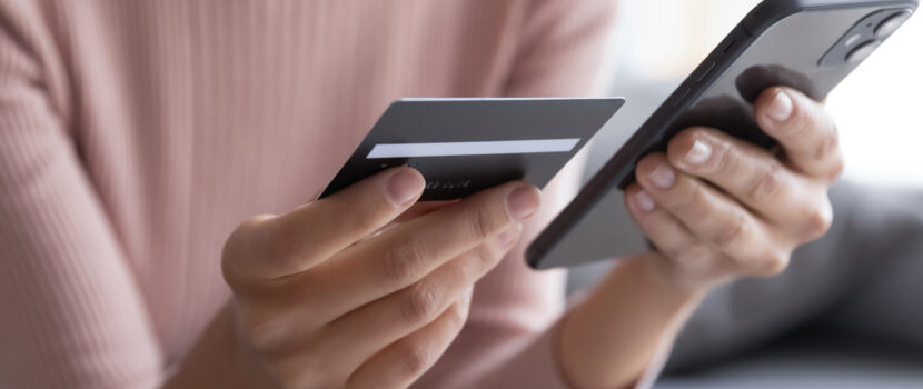 A woman entering bank card details into a phone.