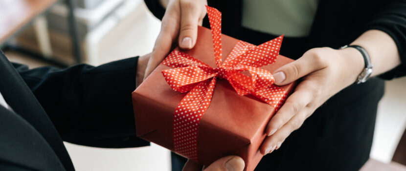 Someone handing a person a wrapped gift.