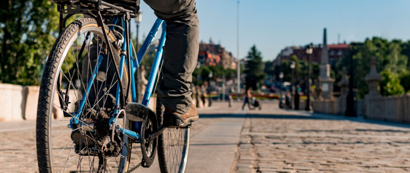 A man riding a bike through a city.